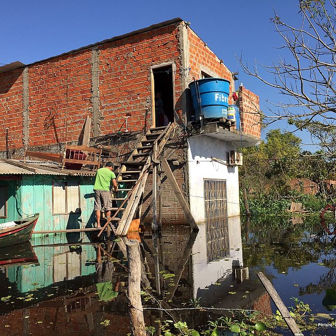 flooded house with rain water barrel next to staircase