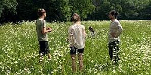 people standing in the grass on a field